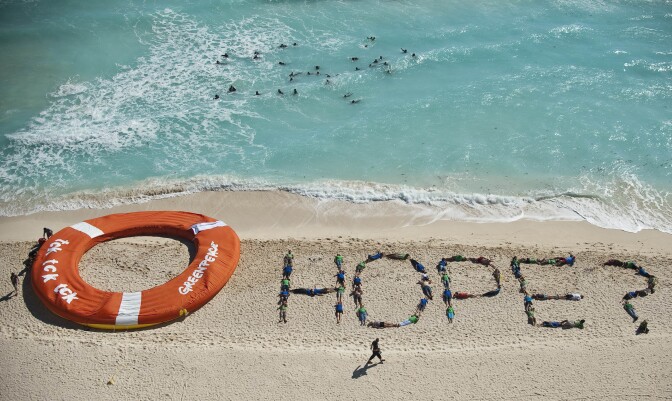 Members of Greenpeace make a performance using a giant inflatable life ring, in a beach of Cancun Mexico, on December 10, 2010 during the COP16 United Nations Climate Change conference.  