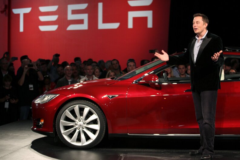 Tesla's Elon Musk standing near his Model S. Steve Levine says Musk is absolutely winning the war for the electric car. 