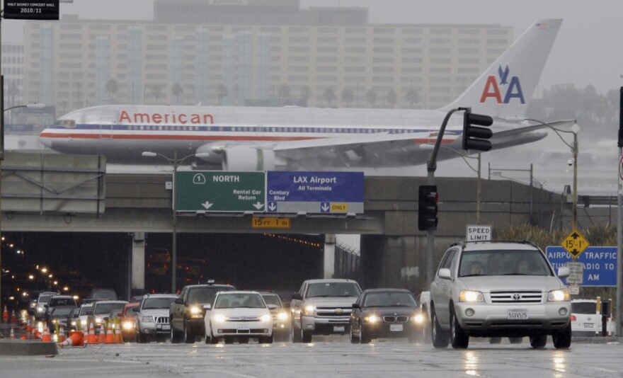 File: Traffic through the Sepulveda Boulevard tunnel under Los Angeles International Airport is backed up as a lane is closed due to flooding while an airliner lands, as rain falls on a large part of Southern California Wednesday, Oct. 6, 2010.