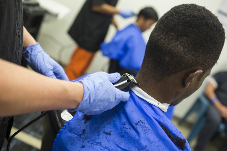 A detainee receives a haircut in the barbershop room at the U.S. Immigration and Customs Enforcement's Detention Facility in Adelanto on Friday, Sept. 2, 2016.