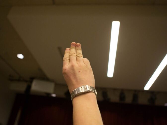 A scout holds up three fingers as he recites the Scout Oath at a meeting of Boy Scout Troop 36 at Beth Hillel Temple in North Hollywood.