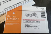 A ballot return envelope addressed to the LA County Registrar-Recorder, marked 'Official Election Mail' with no postage required.