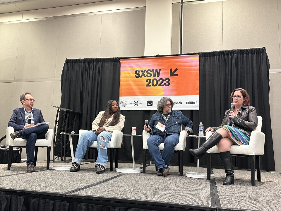 A diverse group of four people sit in white chairs on stage in front of a SXSW 2023 sign.