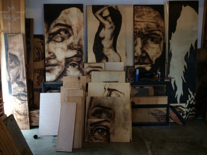 Aronson’s work looks like charcoal drawings from a distance, but he actually chars the wood with flame to create a similar look. 