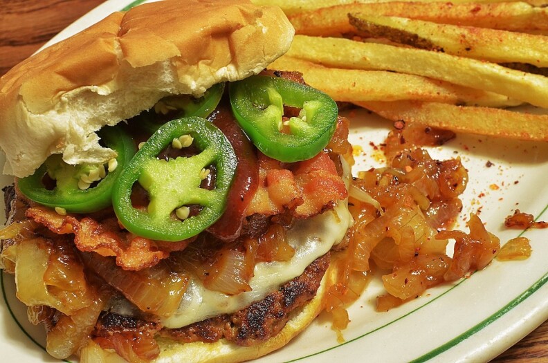 A BBQ-sauced bacon cheeseburger with caramelized onions.