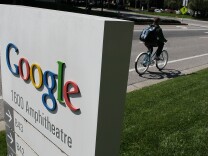 A bicyclist rides by a sign outside of the Google headquarters March 10, 2010 in Mountain View, California. Google announced today that they are adding bicycle routes to their popular Google Maps and is available in 150 U.S. cities.  