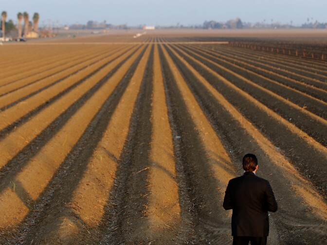 A sercret service agent looks over a farm field as President Barack Obama speaks to the media on California's drought situation on February 14, 2014 in Los Banos, California. Obama met with farmers and ranchers while pledging millions of dollars in federal funds for drought relief projects in California   
