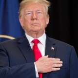 US President Donald Trump stands for the National Anthem during a swearing-in ceremony for Gina Haspel as Director of the Central Intelligence Agency at CIA Headquarters in Langley, Virginia, May 21, 2018. (Photo by SAUL LOEB / AFP)        (Photo credit should read SAUL LOEB/AFP/Getty Images)