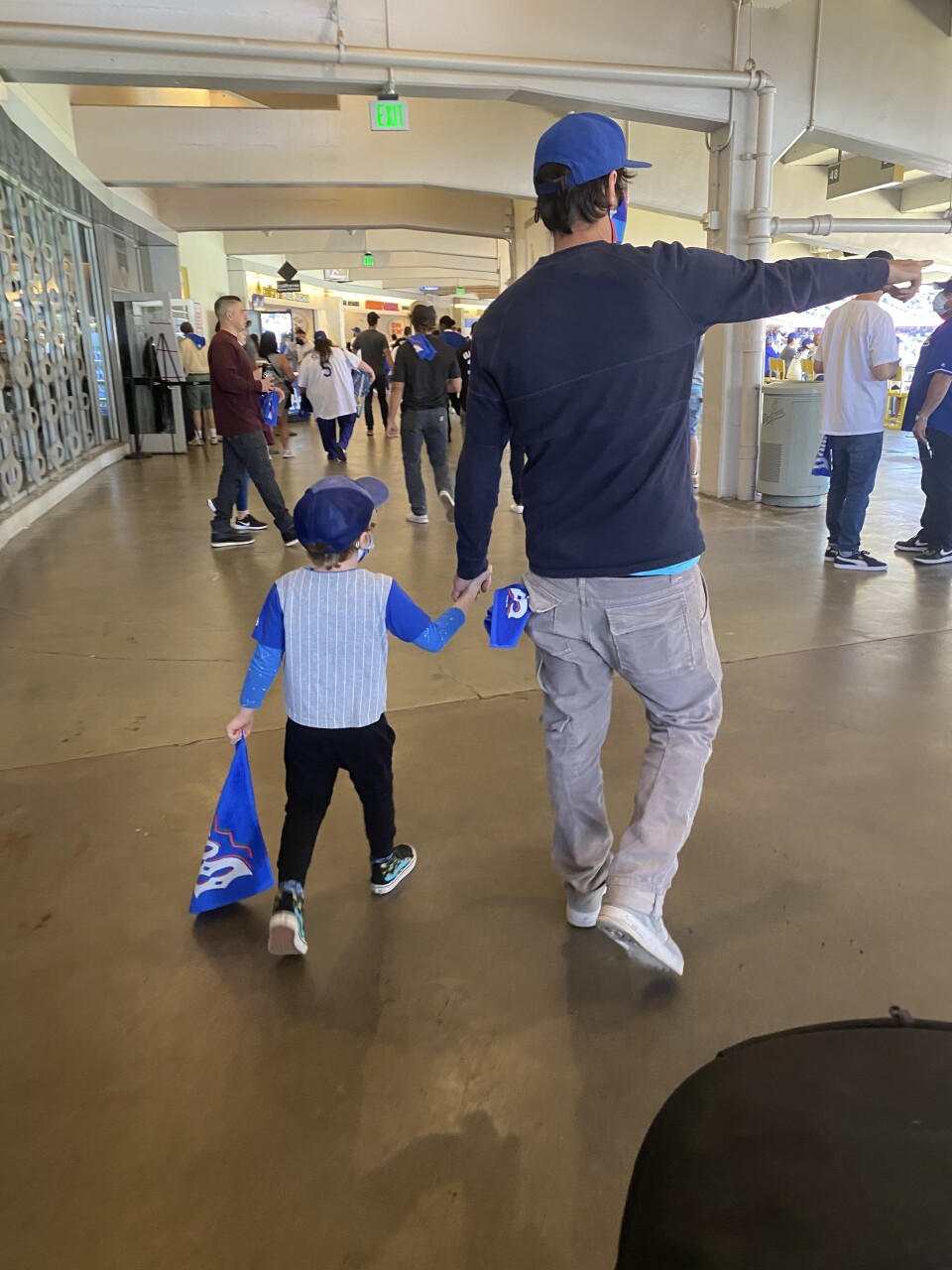 Image of back of father and son walking through the hallways of Dodger Stadium.
