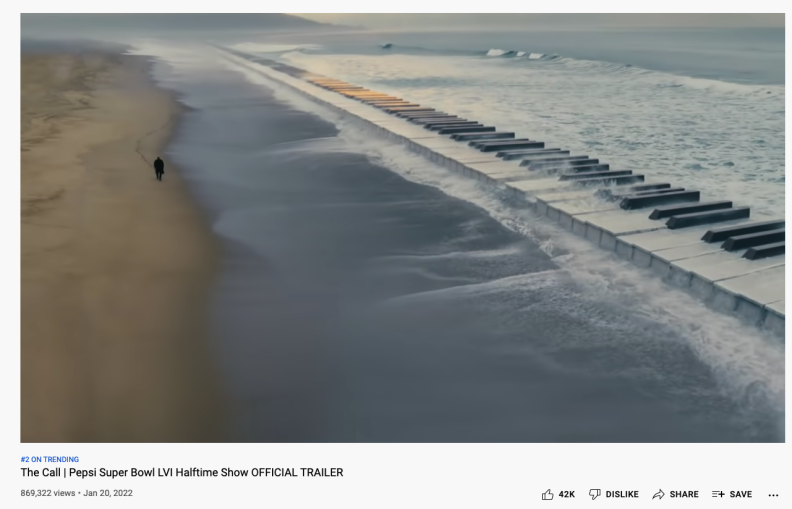 A massive keyboard rises from the ocean as waves roll to shore.
