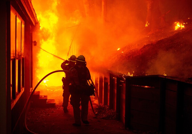A house is engulfed in flames as firefighters attempt to put it out during the Valley Fire in Seigler Springs, California on September 13, 2015. The governor of California declared a state of emergency Sunday as raging wildfires spread in the northern part of the drought-ridden US state, forcing thousands to flee the flames. The town of Middletown, population 1,300, was particularly devastated by the Valley Fire, according to local daily Santa Rosa Press-Democrat, which said the fire grew from 50 acres to 10,000 over just five hours Saturday -- before quadrupling in size overnight. 