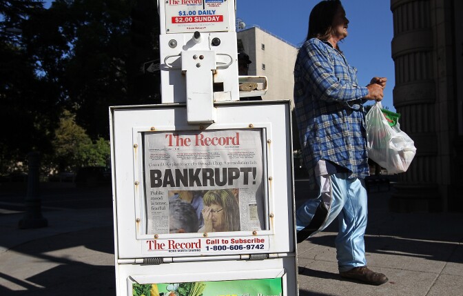 STOCKTON, CA - JUNE 27:  A pedestrian walks by a Stockton Record newspaper rack displaying the headline "Bankrupt!"  on June 27, 2012 in Stockton, California. Members of the Stockton city council voted 6-1 on Tuesday to adopt a spending plan for operating under Chapter 9 bankruptcy protection following failed talks with bondholders and labor unions failed.  The move will make Stockton the biggest U.S. city to file for bankruptcy protection from creditors.  (Photo by Justin Sullivan/Getty Images)