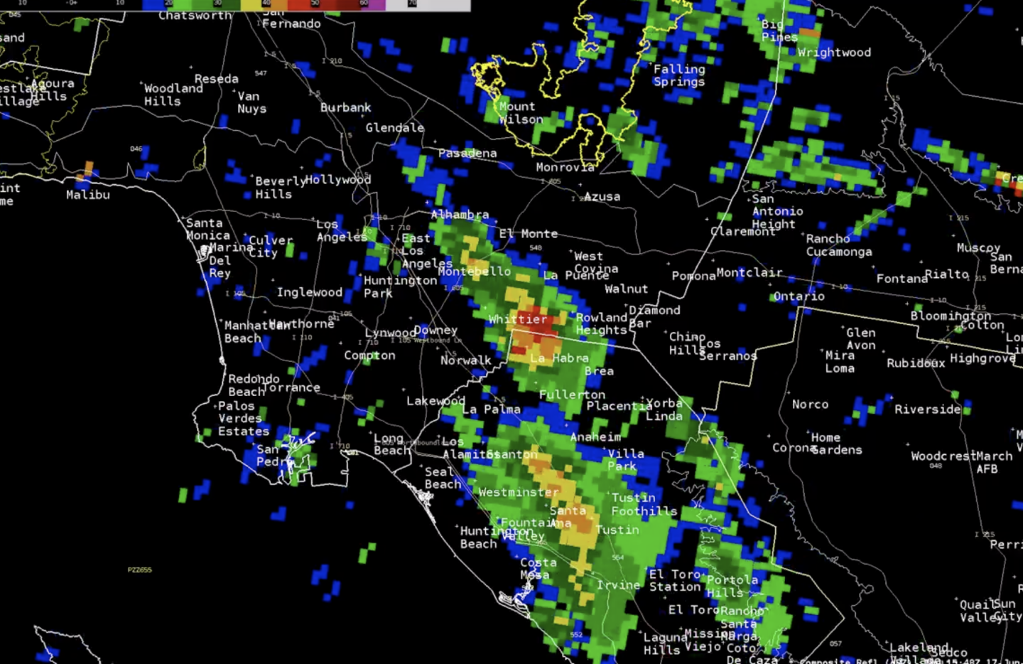 Image from National Weather Service shows bright green and yellow rain pockets moving through Southern California, over a black map.