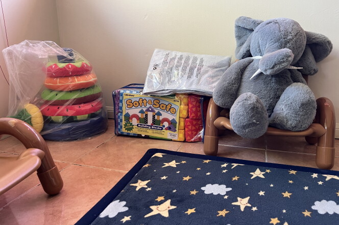 A close up of children's toy blocks and furniture, with a dark rug with stars and clouds in the foreground. 