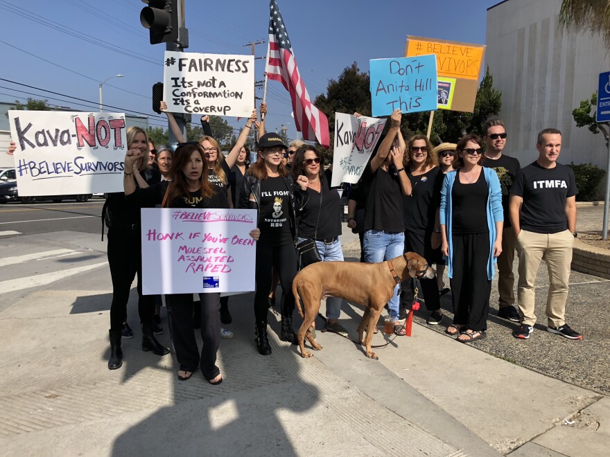 Protesters chant at passing cars while some drivers respond with a honk in solidarity.
