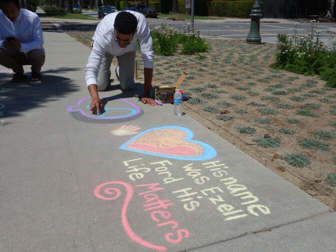                                Artist Foremost begins a chalk portrait of Ezell Ford on the sidewalk outside Los Angeles Mayor Eric Garcetti's official residence. Activists said they planned to remain outside the mayor's mansion until the Police Commission meets on Tuesday to decide if the fatal shooting of Ford was within police use-of-force policy.