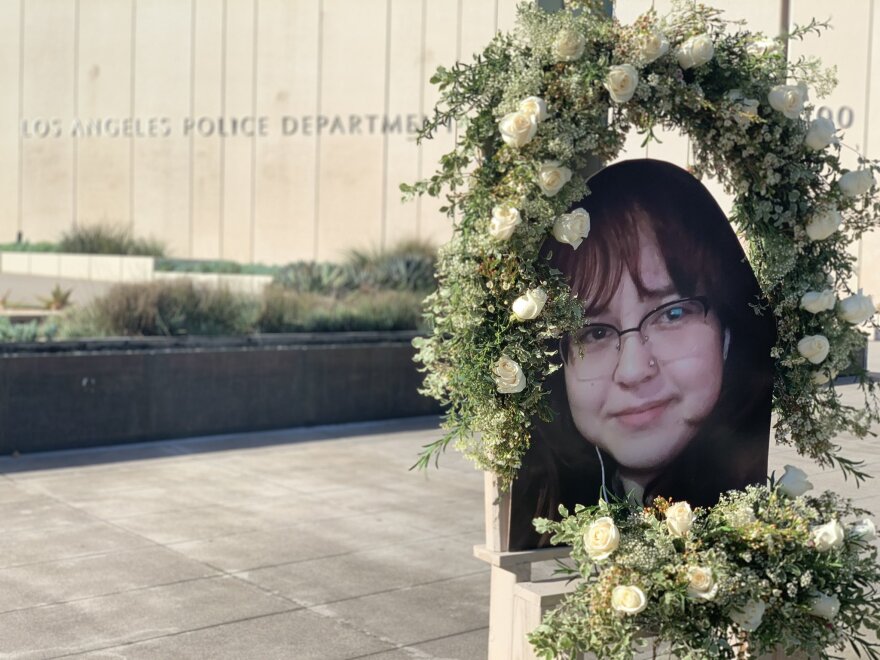A wreath with white flowers adorns a picture of Valentina Orellana Peralta, the 14-year-old who was shot by police during an altercation with a suspect. The wreath and photo is seen in front of the LAPD headquarters building.