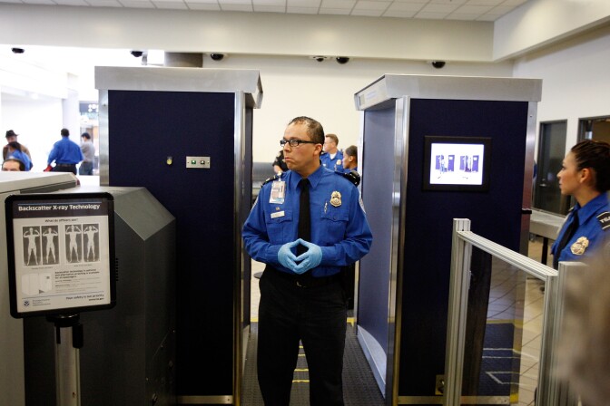 TSA agents stand near an Advanced Imaging Technology (AIT) full-body scanner at Los Angeles International Airport (LAX) on November 22, 2010 in Los Angeles, California. AIT scanners see through clothing to photograph the entire body to reveal undisclosed objects. Increasing use of the scanner at airports by the Transportation Security Administration (TSA) is being met with outrage by many US travelers. Passengers who refuse an X-ray scan are required to undergo an intimate pat down by TSA agents. 