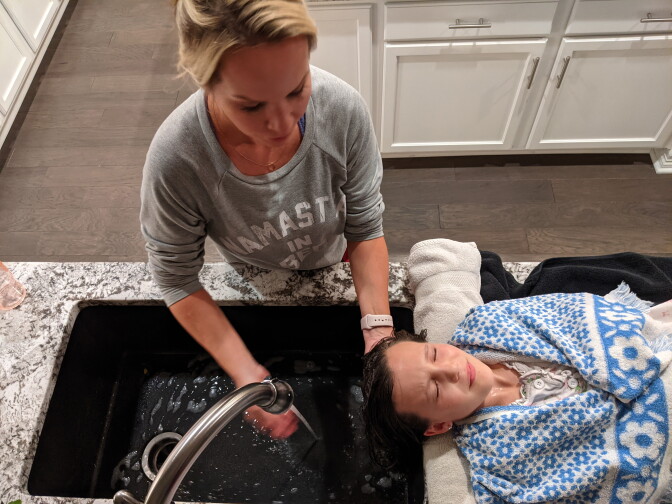 Paris Marker washes olive oil out of her daughter's hair after LiceDoctors technician Linda Holmes finished combing through it, looking for lice and nits — the eggs of the parasitic insects. The Markers paid more than $200 for Holmes to check and delouse everyone in the four-person household in Parker, Colorado.