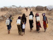 DADAAB, KENYA - JULY 22:  Somalian refugees return from collecting water at the edge of the Dagahaley refugee camp which makes up part of the giant Dadaab refugee settlement on July 22, 2011 in Dadaab, Kenya. The refugee camp at Dadaab, located close to the Kenyan border with Somalia, was originally designed in the early 1990s to accommodate 90,000 people but the UN estimates over four times as many reside there. The ongoing civil war in Somalia and the worst drought to affect the Horn of Africa in six decades has resulted in an estimated 12 million people whose lives are threatened.  (Photo by Oli Scarff/Getty Images)