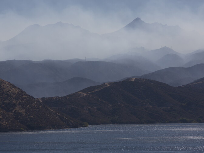 Smoke from the Pilot fire blows over the hills above Silverwood Lake in California on August 9th, 2016. 