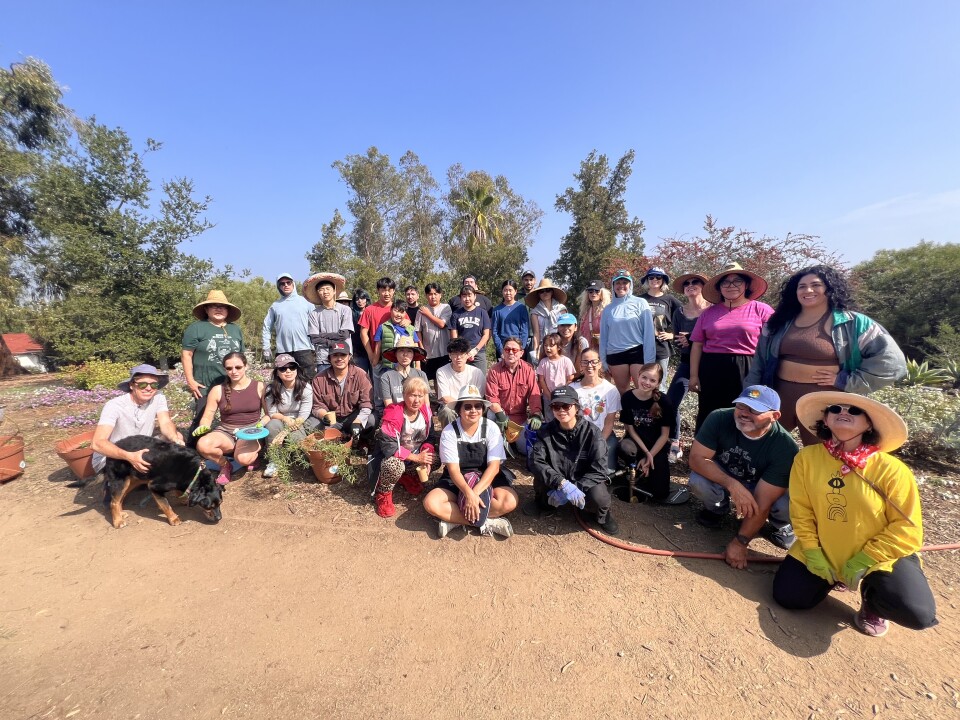 Dozens of volunteers smile for a group photo at Elysian Park in Los Angeles. 