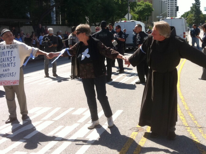 At least 14 protesters hold hands in the middle of Los Angeles Street in front of the Federal Building on October 7, 2011.
