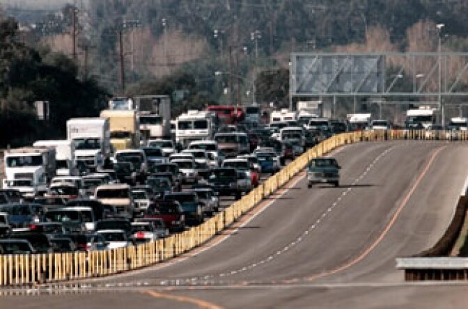 A freeway construction truck travels on part of the 10-mile stretch of the world's first fully-automated toll road built along state Highway 91 before its official opening Wednesday, Dec. 27, 1995, in Anaheim, Calif. Traffic on Highway 91, on the left, slowed to a crawl for four miles because of the ribbon cutting ceremony in the freeway median ahead.
