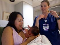 Registered Nurse Tracey Desai gives tips to new mother Lani on how to position her daughter while breastfeeding. Lani said she wanted to breastfeed her child from the beginning, and feels that the benefits outweigh the difficulties.