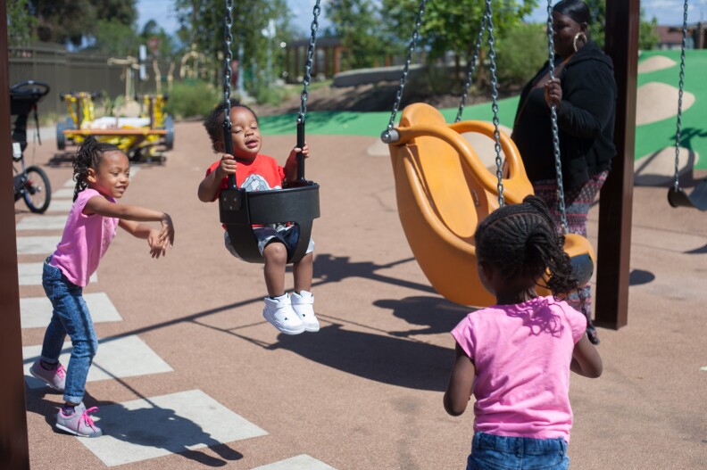 Twins Zoe and Zora McLucas, 4, push Roya Cole, 1 in a swing at the the newly completed Serenity Park in Watts, Calif.  on Monday, April 6, 2015. The kids come to the park everyday to play for an hour.