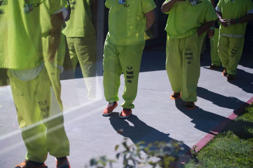 Men wearing neon-colored jail clothes signifying immigration detainees walk to pick up their lunches at the Theo Lacy Facility, a county jail which houses convicted criminals as well as immigration detainees, March 14, 2017 in Orange, California, about 32 miles (52km) southeast of Los Angeles.
US President Donald Trumps first budget provides more than USD 4.5 billion in new spending to fight illegal immigration by adding immigration and border enforcement agents, prosecutors and judges, as well as building a wall on the border with Mexico. / AFP PHOTO / Robyn Beck        (Photo credit should read ROBYN BECK/AFP/Getty Images)