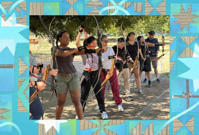 Several people of different ages and heights are lined up in a row, holding bow and arrows as part of an archery lesson.