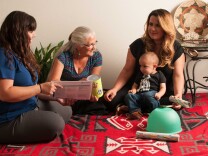 Jaclyn Gray, left, project coordinator for the Riverside‐San Bernardino County Indian Health Home Visiting Program, visiting a family in Riverside County.