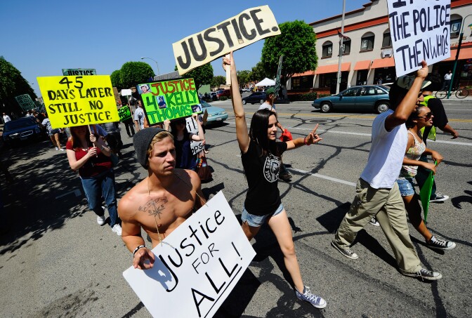 Demonstrators march in 2011 to protest the death of Kelly Thomas, a homeless man who died in July 2011 after an altercation with several Fullerton police officers.  