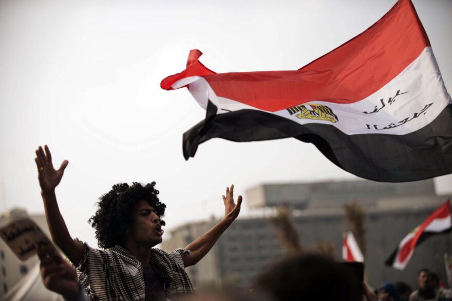 Egyptian protesters wave their national flag as they shout political slogans against President Mohamed Morsi's decree granting himself broad powers during a demonstration in Cairo's Tahrir Square on November 27, 2012. The planned demonstrations come a day after Morsi met with the country's top judges in a bid to defuse the crisis over the decree, that has sparked deadly clashes and prompted judges and journalists to call for strike.