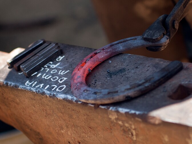 After heating horseshoes in charcoal, Bryan Jones hammers the pieces into shape.