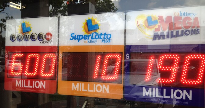 The winner of the Powerball jackpot stepped forward Wednesday to claim the $590 million prize.   Powerball lottery officials say the winning ticket was sold in Zephyrhills, Florida.  (Photo: Sign in store window displays Powerball lottery jackpot. Ed Joyce/KPCC)