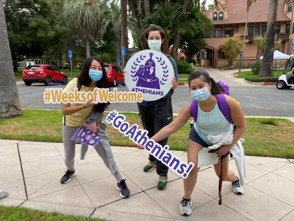 Mt. St. Mary's University students hold "Go Athenians" and "Weeks of Welcome" signs.