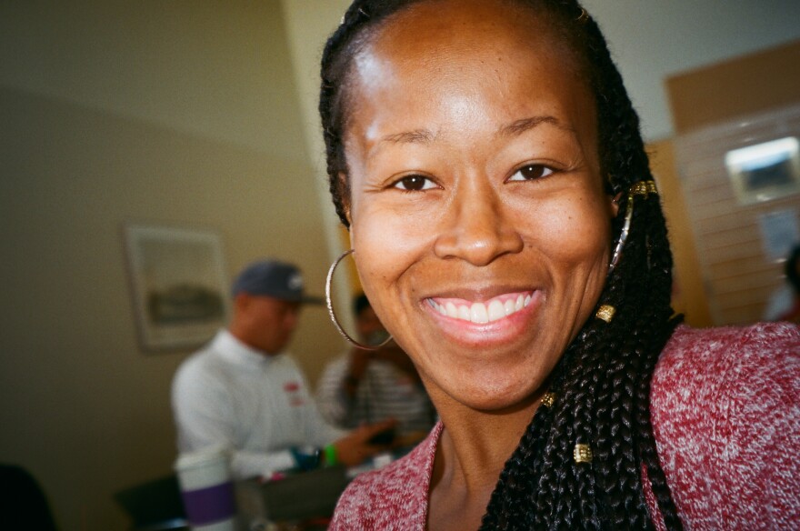A selfie shows Shammeer Dawsome with a wide smile, hoop earings and cornrow braids worn over one shoulder.