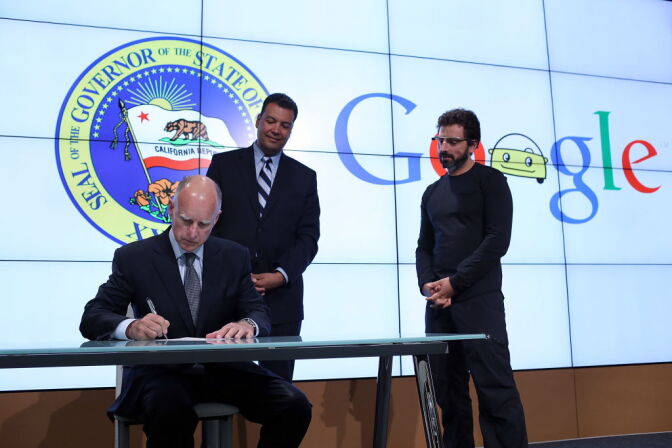 California Gov. Jerry Brown (L) signs State Senate Bill 1298 as California State Sen. Alex Padilla (C) and Google co-founder Sergey Brin (R) look on at the Google headquarters on September 25, 2012 in Mountain View, California.  California Gov. Jerry Brown signed State Senate Bill 1298 that allows driverless cars to operate on public roads for testing purposes. The bill also calls for the Department of Motor Vehicles to adopt regulations that govern licensing, bonding, testing and operation of the driverless vehicles before January 2015.