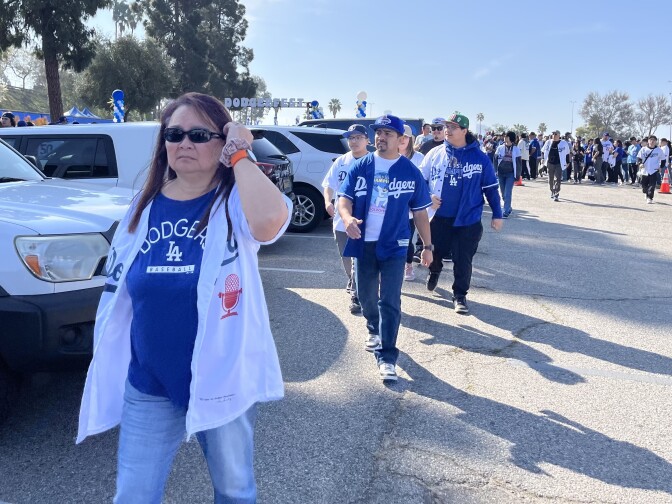 Fans wearing blue Dodgers T-shirts and jerseys walk toward Dodger Stadium for DodgerFest 2025.