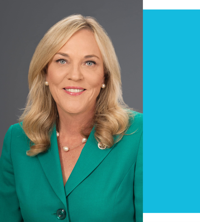 Los Angeles County Supervisor Kathryn Barger is photographed smiling in a headshot wearing a green jacket and necklace.