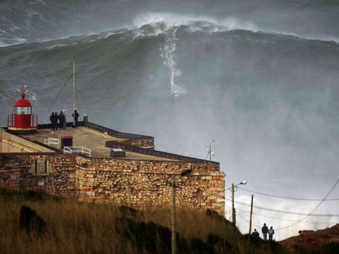 This photo released Tuesday Jan. 29, 2013, by Nazare Qualifica organization, US surfer Garrett McNamara rides a wave off Praia do Norte beach in Nazare, Portugal, on Monday Jan. 28, 2013.  McNamara is said to have broken his own world record for the largest wave surfed when he caught this wave reported to be around 100ft, off the coast of Nazare on Monday.  If the claims are verified, it will mean that McNamara, who was born in Pittsfield, Massachusetts but whose family moved to Hawaii's North Shore when he was aged 11, has beaten his previous record, which was also set at Nazare, of 23.77 meters (78 feet) in November 2011. 