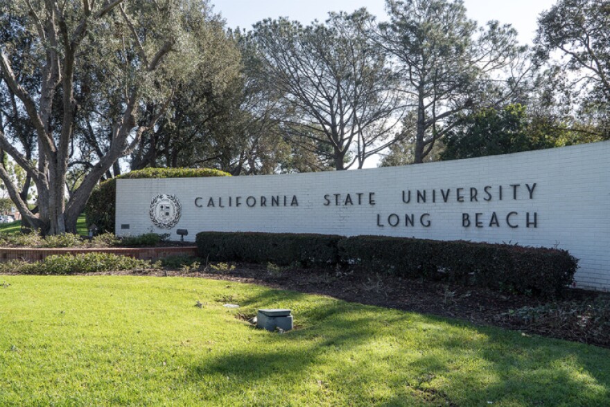 On a curved white brick wall lettering in slim font reads: California State University Long Beach.