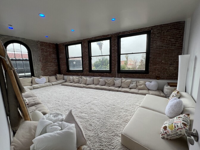 A room of white and tan cushions and carpet. 