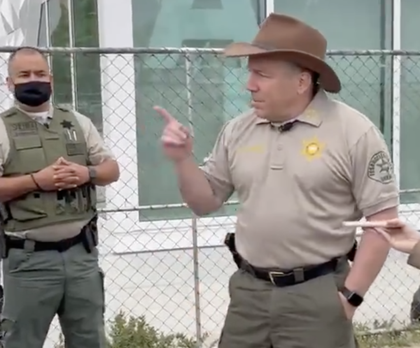 An image of Sheriff Alex Villanueva wearing a cowboy hat and gesturing with his index finger as he speaks near the Venice Boardwalk.