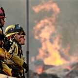 MALIBU, CA - NOVEMBER 11: Firefighters battle a blaze at the Salvation Army Camp on November 10, 2018 in Malibu, California. The Woolsey fire has burned over 70,000 acres and has reached the Pacific Coast at Malibu as it continues grow.  (Photo by Sandy Huffaker/Getty Images)