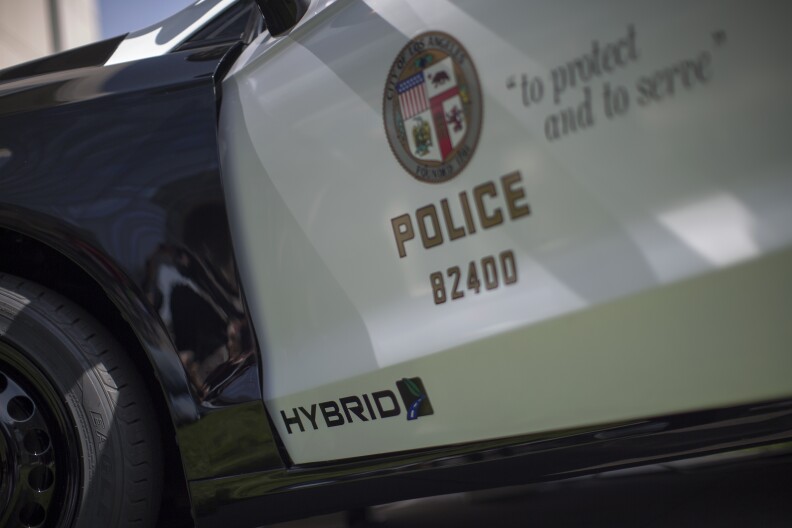 An LAPD car with its emblem on the side of the driver's door with the phrase to protect and to serve.