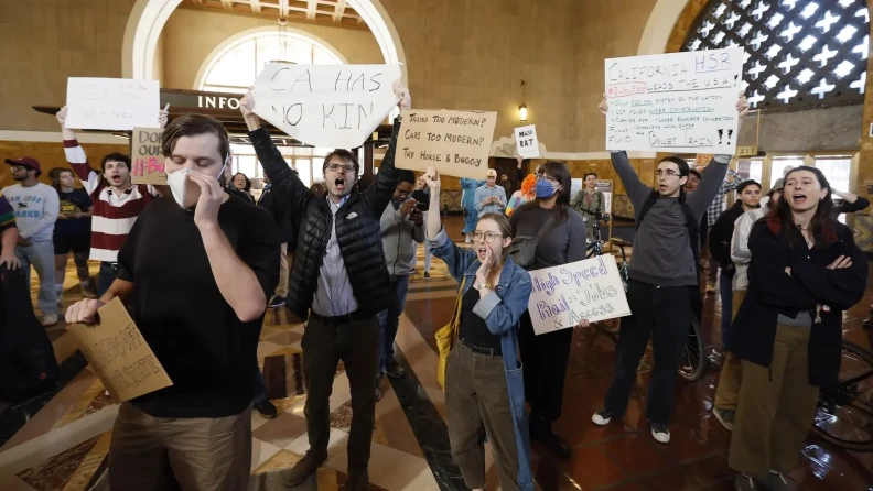 People hold signs and chant inside Los Angeles' Union Station.
