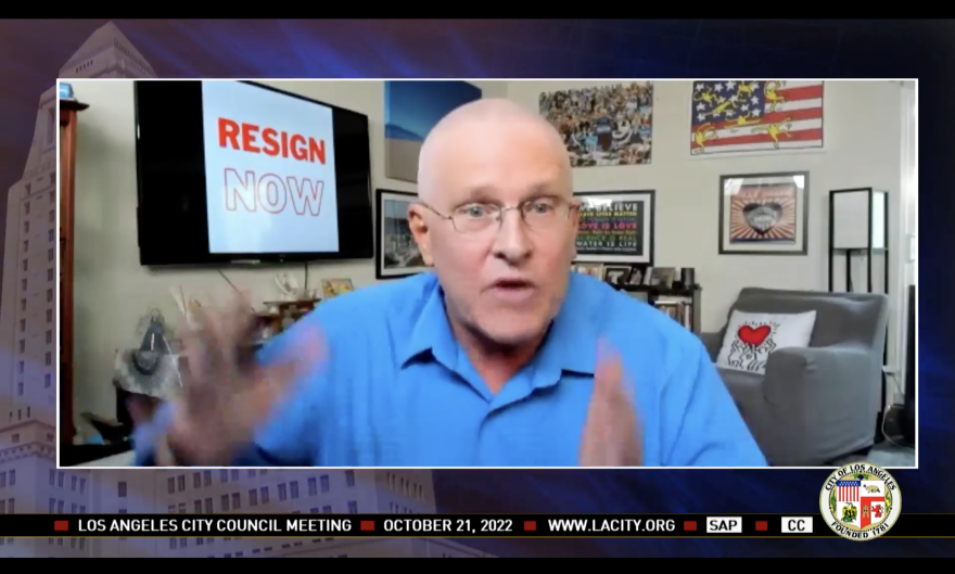 A screenshot of a Council Member Mike Bonin with a "Resign Now" sign in the background.